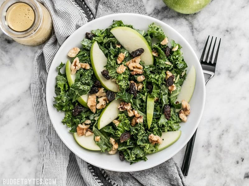 Overhead view of Apple Dijon Kale Salad in a bowl with a black fork