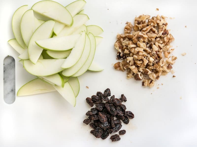 Apples Walnuts and Raisins prepped on a cutting board