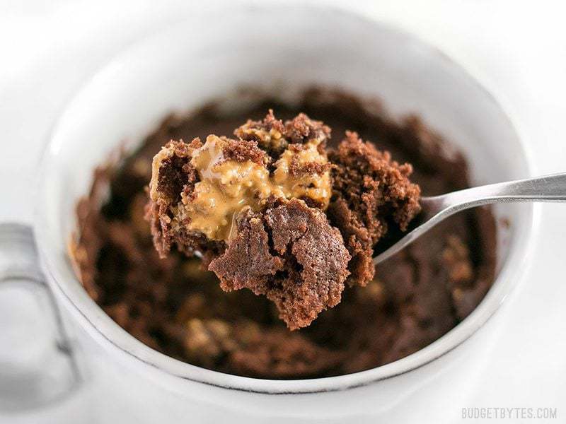 Close up side view of a spoonful of chocolate mug cake with melted peanut butter