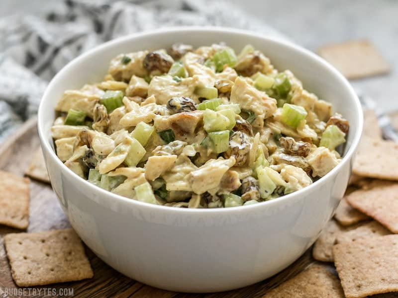 Front view of a bowl of Curry Chicken Salad surrounded by crackers. 