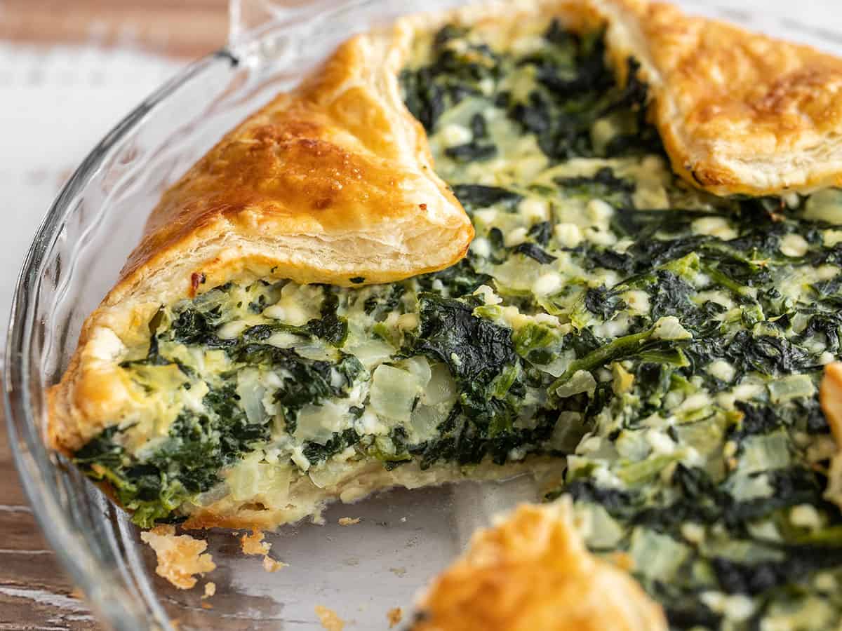 Close up side view of spinach pie in the glass pie dish