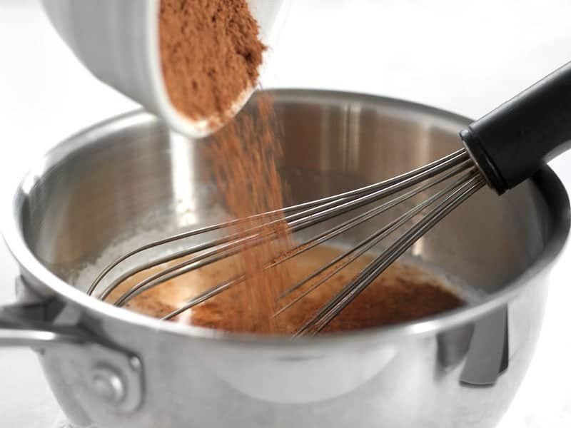 Spices being added to milk in the sauce pot