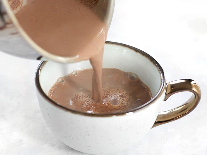 Aztec Hot Cocoa being poured from the sauce pot into a mug