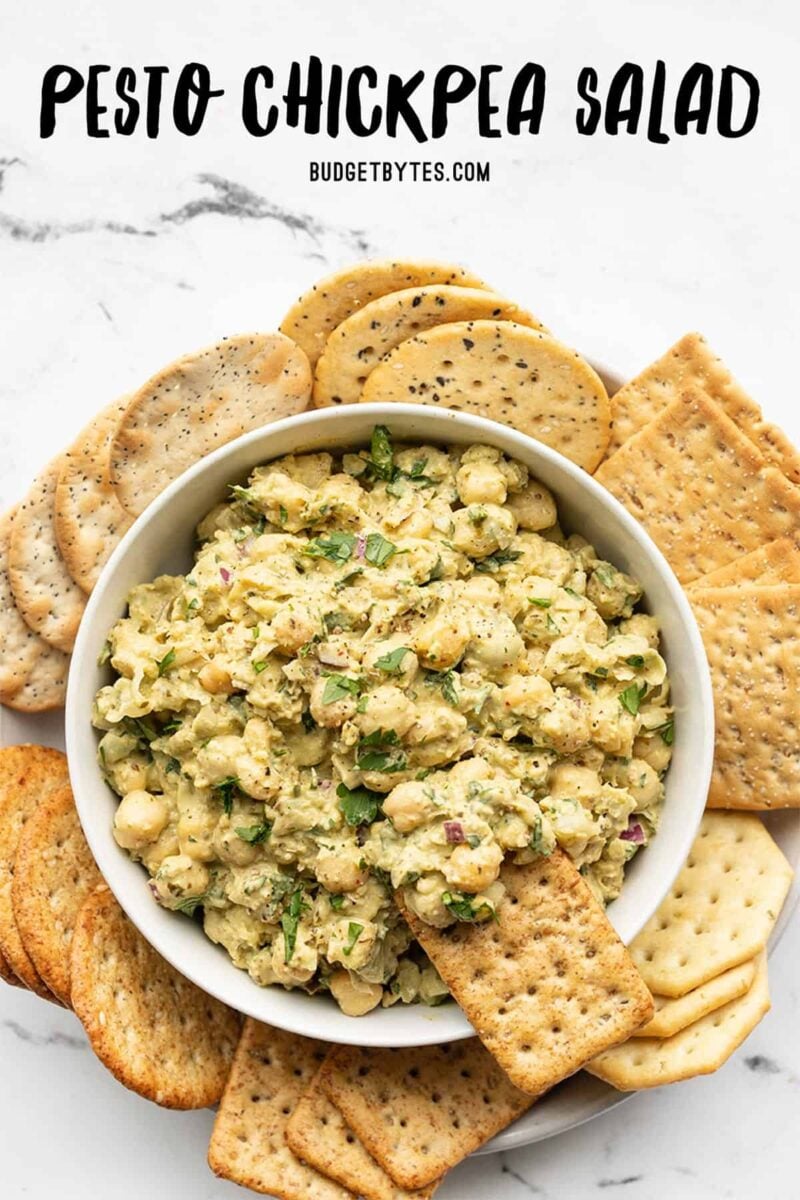 pesto chickpea salad in a bowl surrounded by crackers, title text at the top