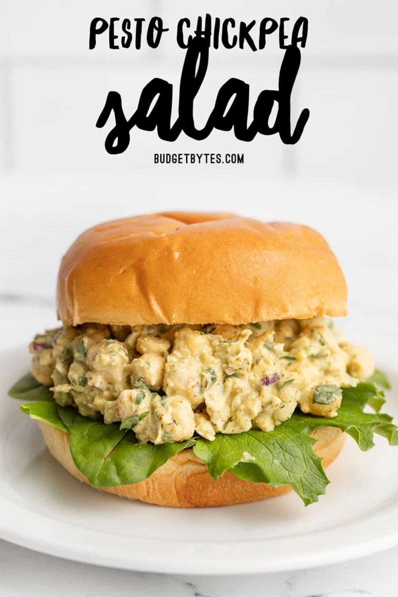 pesto chickpea salad on a bun with greens, title text at the top