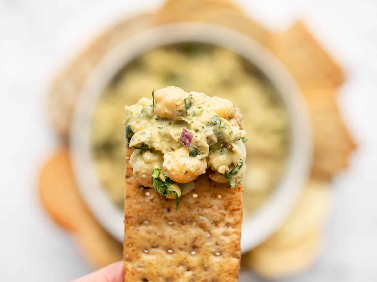 close up of pesto chickpea salad on a cracker