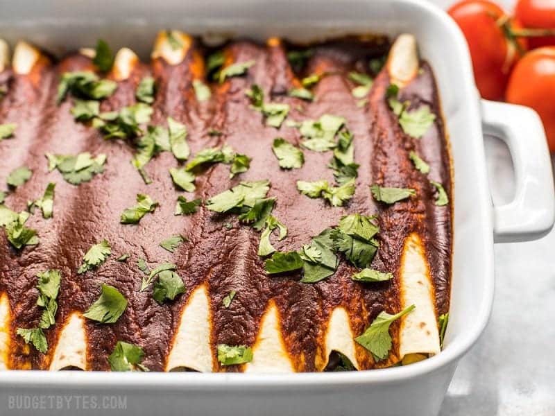 Side view of vegan Black Bean and Avocado Enchiladas in the casserole dish