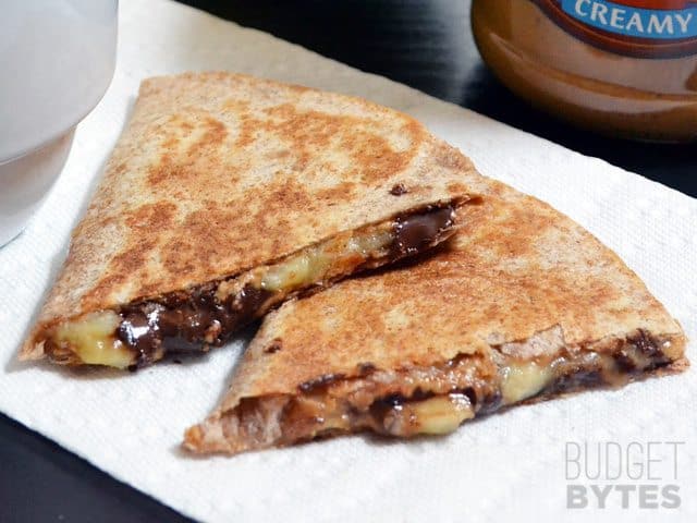Two slices of a Peanut Butter Banana Quesadilla on a paper towel 