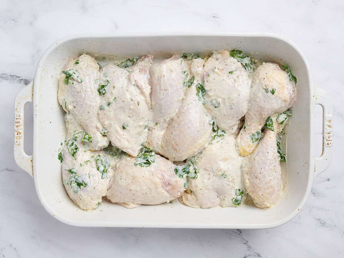 Marinaded chicken pieces in a baking dish.