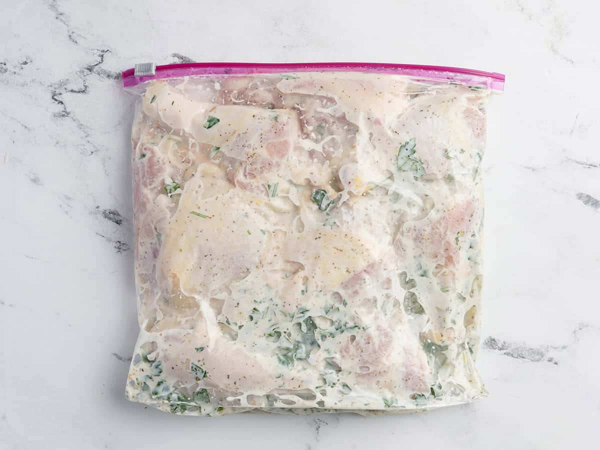 Chicken pieces in a bag with greek marinade.