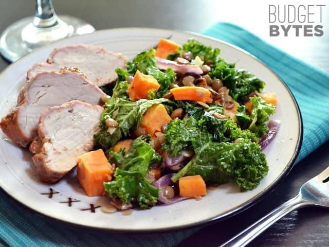 Wilted Kale and Lentil Salad plated with meat on a plate