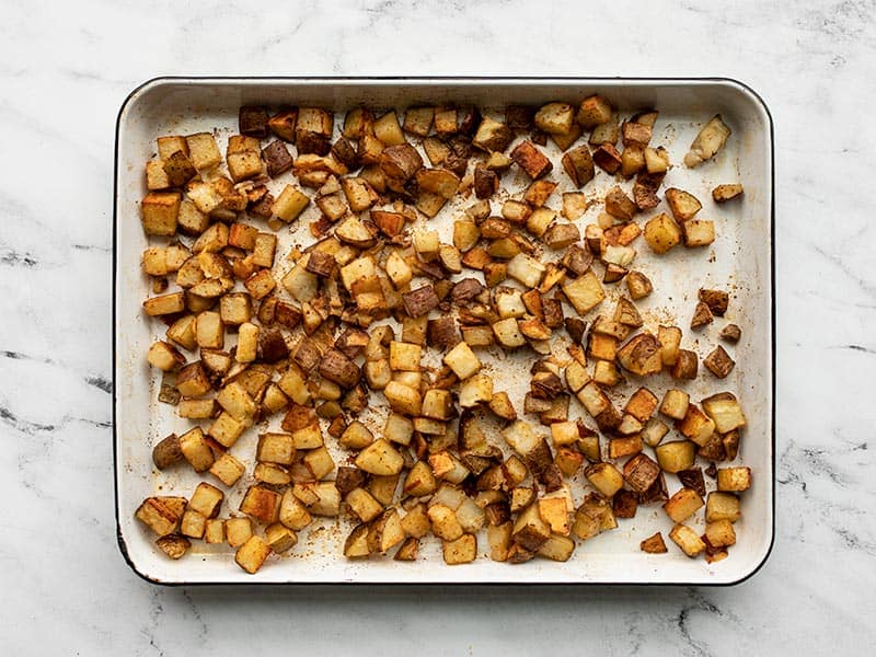 Roasted potato cubes on the baking sheet