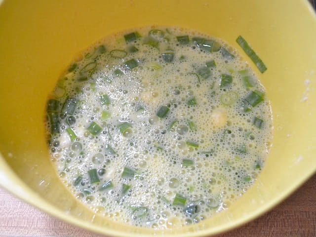 Whisked together eggs, milk, and parmesan in mixing bowl 