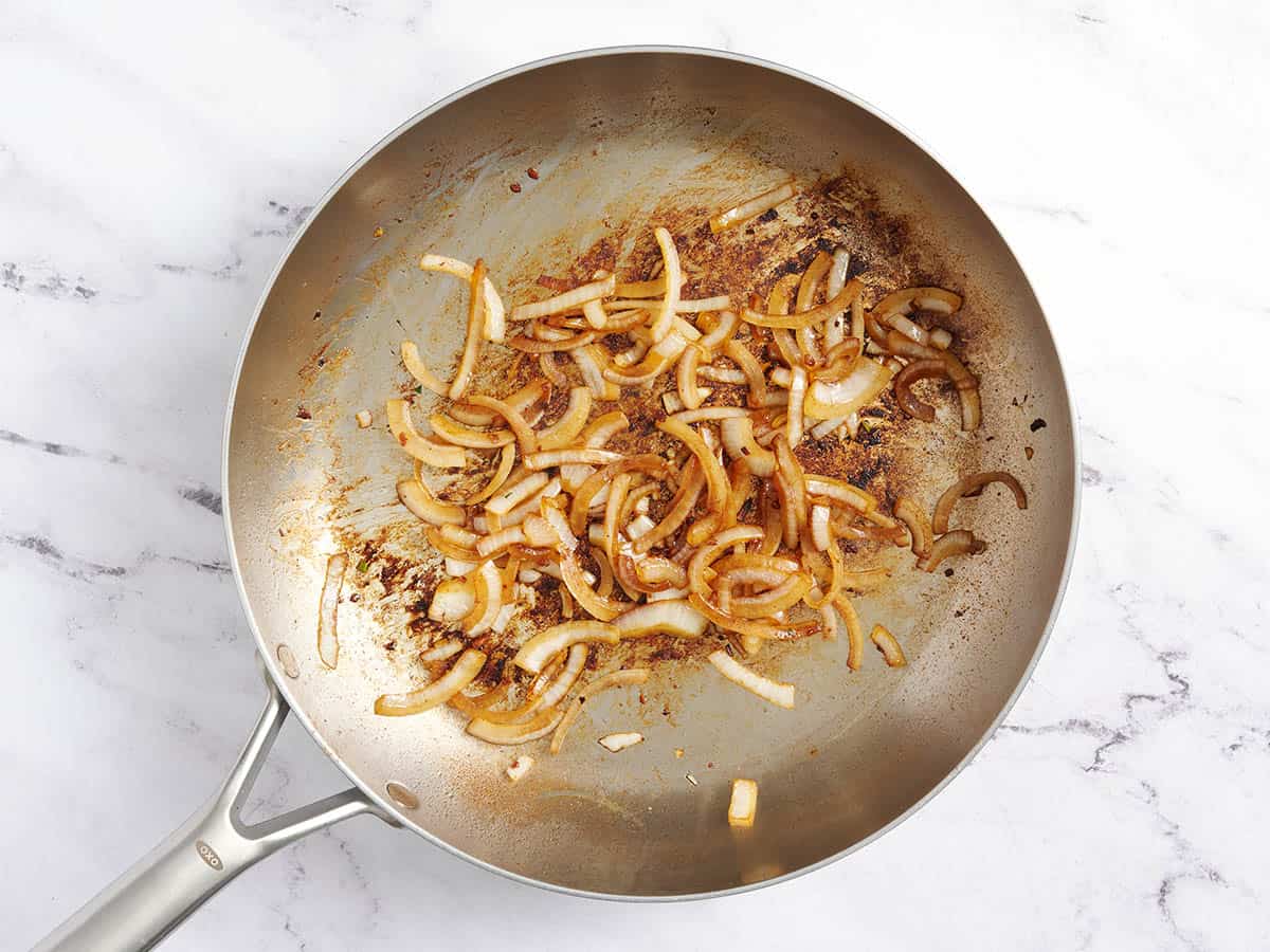 Onions caramelizing in a skillet.