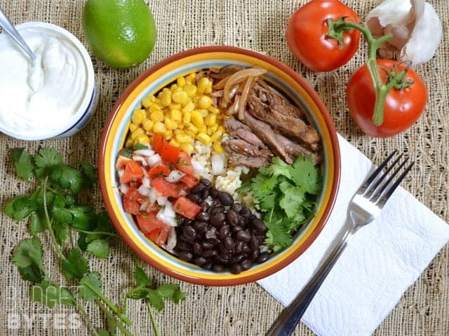 Top view of a Southwest Steak Bowl with staged ingredients on side 