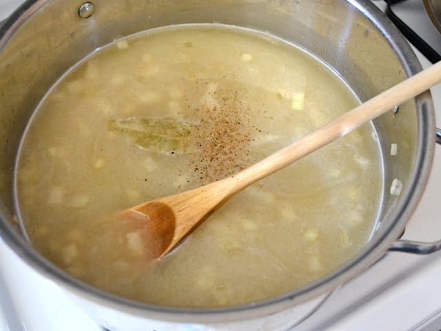 Broth and seasoning added to other ingredients in pot