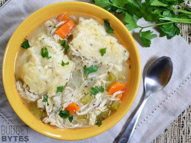 Top view of a bowl of Slow Cooker Chicken and Dumplings with a spoon on the side 