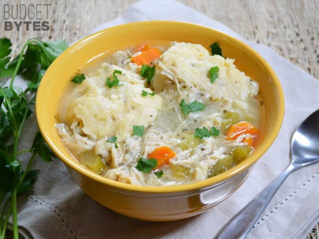 Side view of a bowl of Slow Cooker Chicken and Dumplings with a spoon on the side 