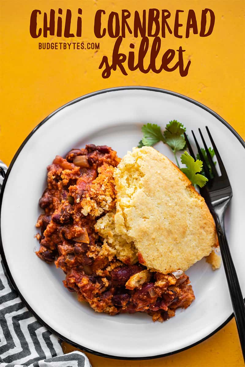 One serving of chili cornbread skillet on a white plate with a black fork, title text overlay at the top.