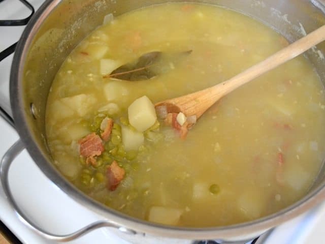 Cooked Soup in pot with wooden spoon