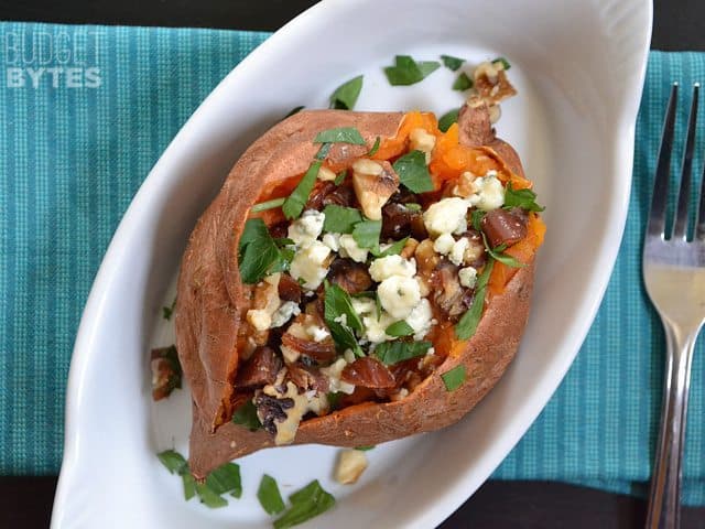 Top view of a Date & Gorgonzola Stuffed Sweet Potatoe in a dish with a fork on the side 