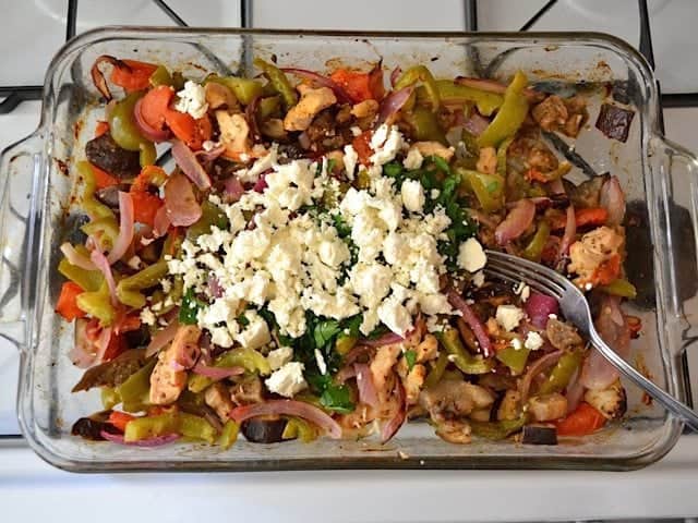 Parsley and Feta mixed into veggies and chicken in baking dish