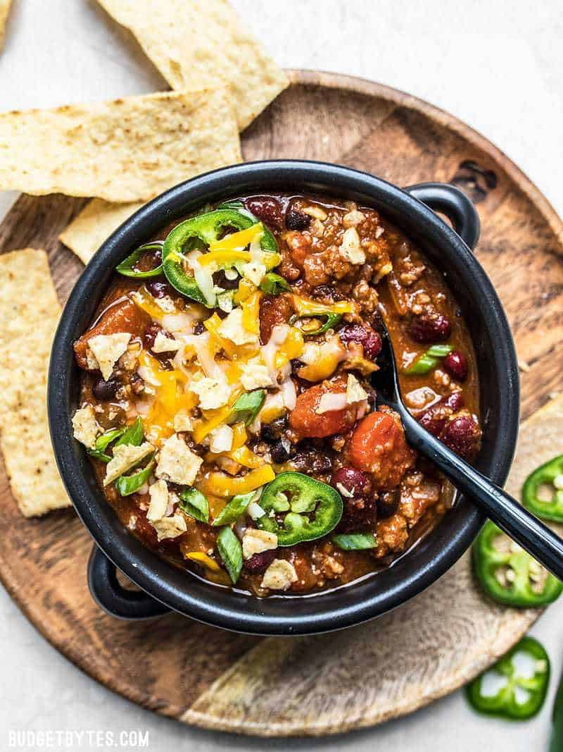 A dressed bowl of homemade chili with plenty of toppings.