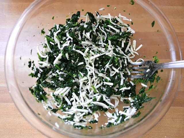 Shredded Mozzarella added to mixing bowl with other ingredients 