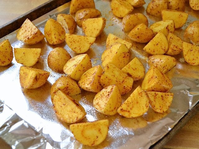 seasoned potatoes placed on baking sheet