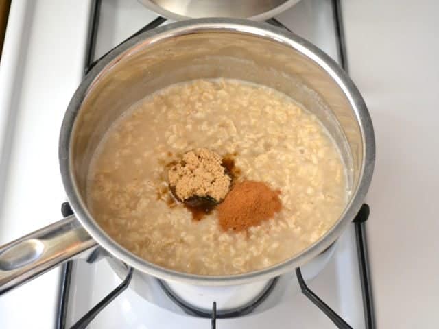 Cooked oats with seasoning added in pan on stove top 