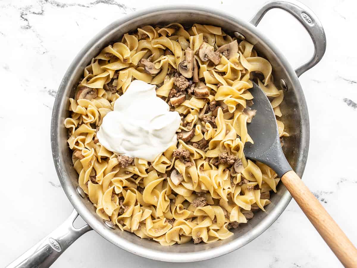 Sour cream added to beef and noodles in the skillet