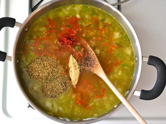Vegetable broth and spices added to pot of other ingredients 