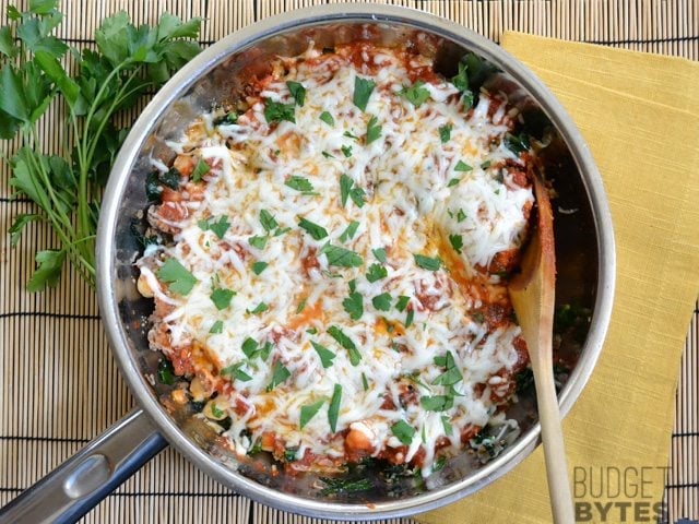 Top view of a cooked Kale & Sausage Skillet with a wooden spoon in it