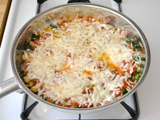 shredded cheese sprinkled over top of dish in skillet and melted