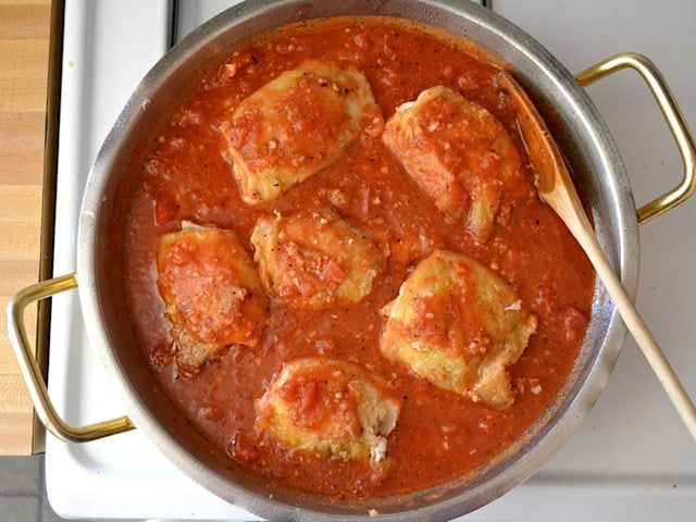 Cooked chicken added to sauce in pan 