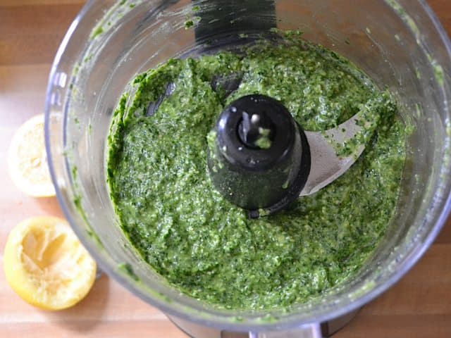 Olive oil added to other ingredients in blender to make pesto sauce 