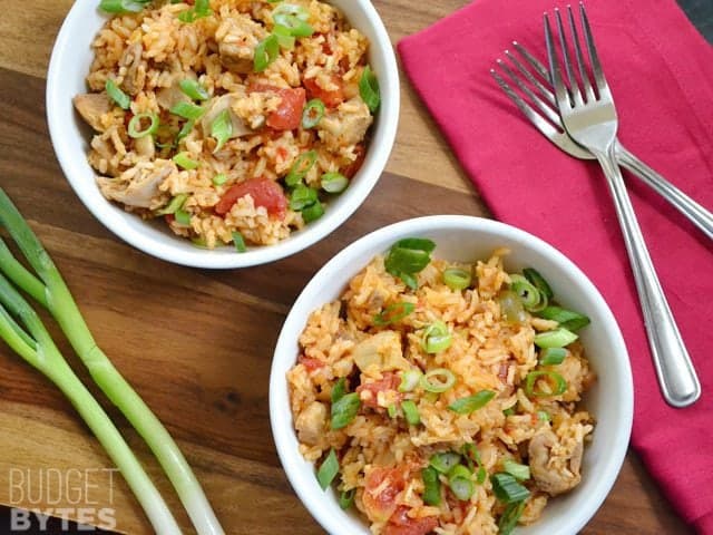 Top view of two bowls of Chorizo Chicken Jambalaya with two forks and red napkins on the side 