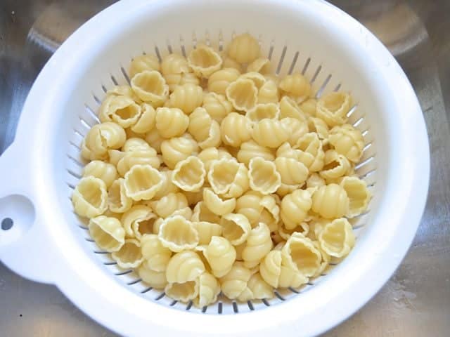 Cooked pasta in colander to drain 