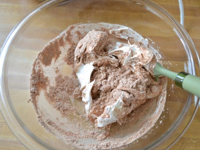 Folding meringue into sifted mixture in mixing bowl 