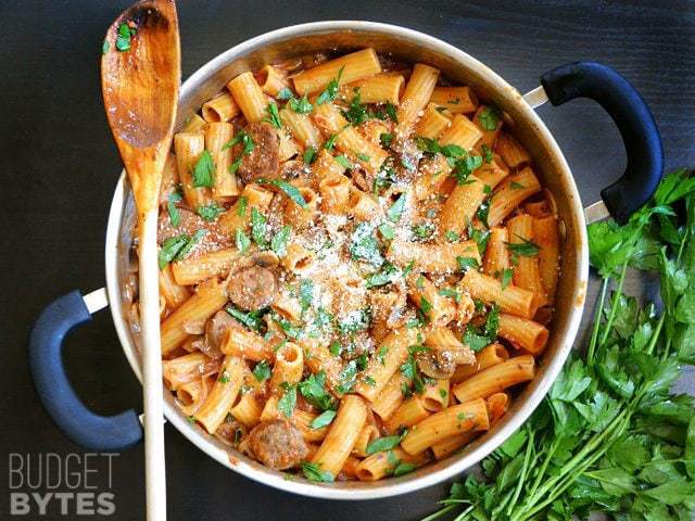 Top view of One Pot Sausage Mushroom Pasta with wooden spoon 