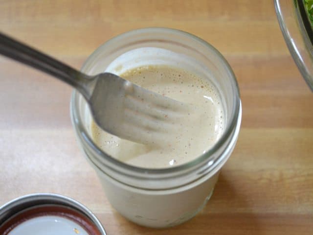 Tahini Dressing in mason jar with fork 