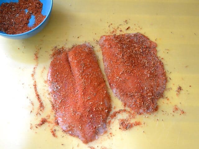 Coated Fish in Blackened Seasoning with bowl of extra seasoning on the side 