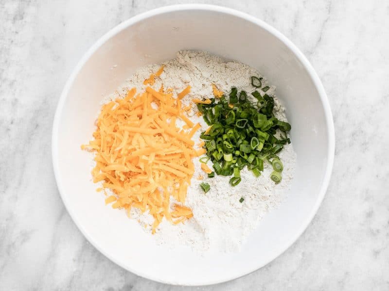 Cheddar and Scallions added to mixing bowl with dry ingredients 