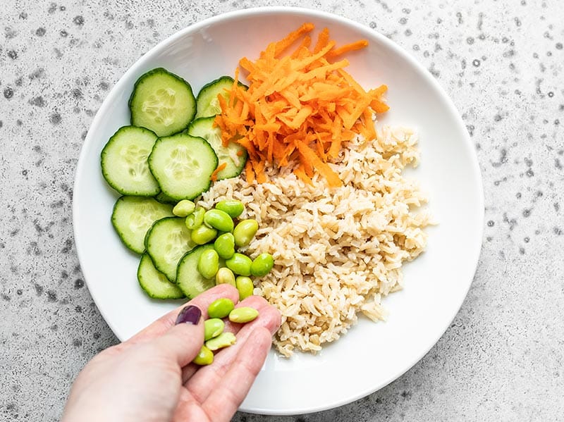 Rice, cucumber, carrots, and edamame in the bowl