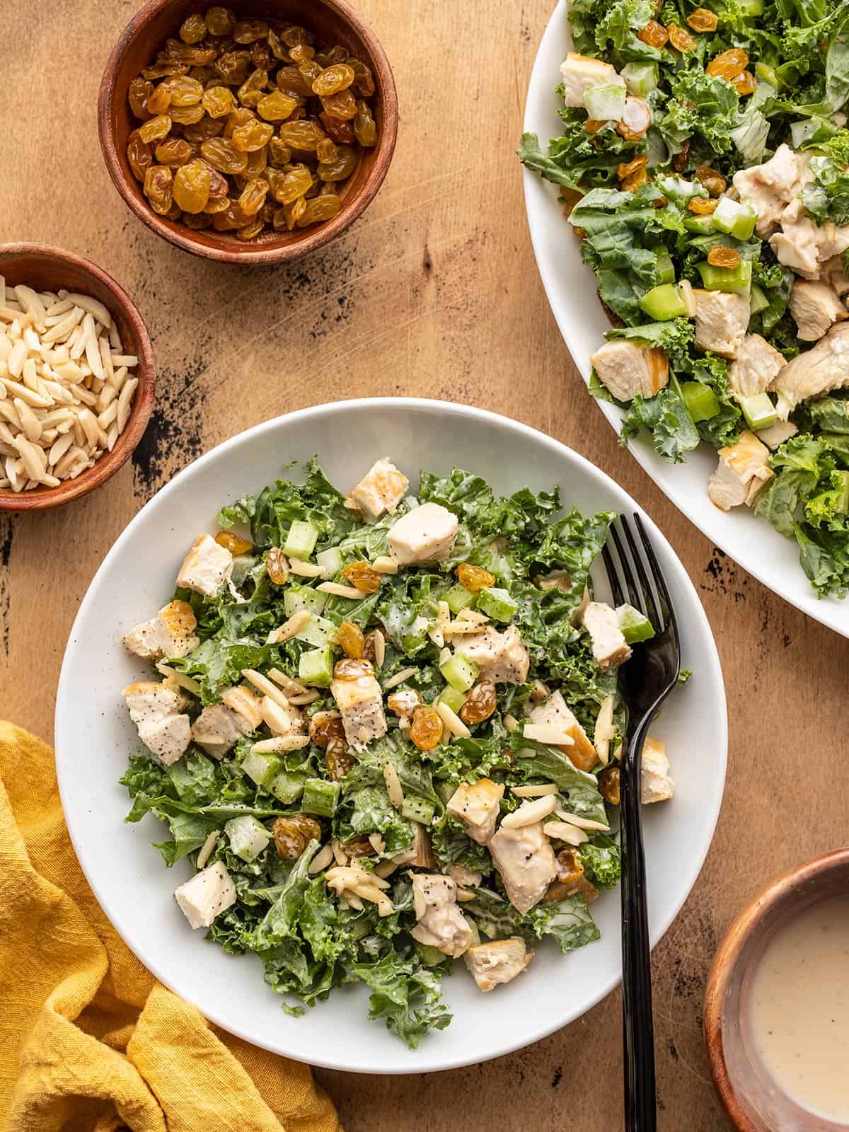 tossed kale salad in a bowl next to the serving platter