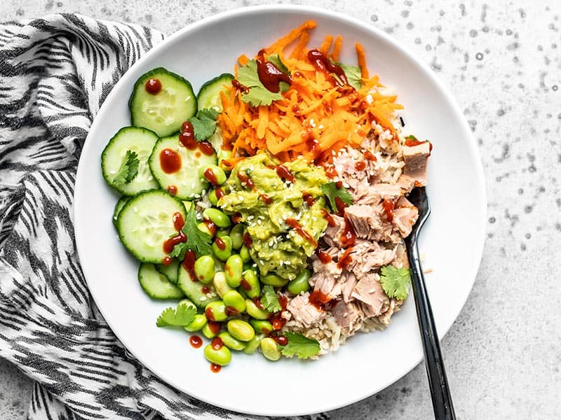 Overhead view of a Spicy Tuna Guacamole bowl with a black fork stuck in the side.