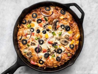 A simple overnight no knead dough makes a perfectly crispy yet thick crust on this no knead pan pizza. Deep dish pan pizza has never been easier. BudgetBytes.com