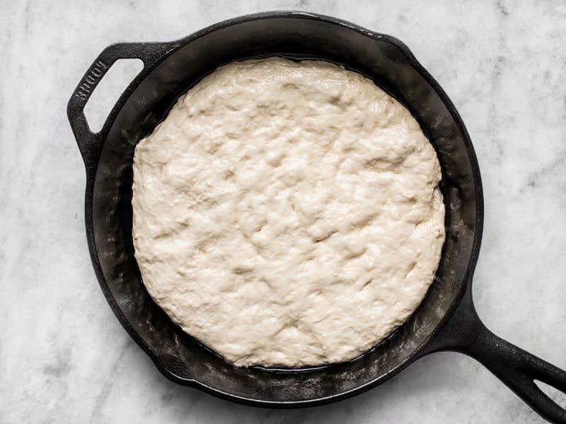 Dough spread out in the bottom of the skillet