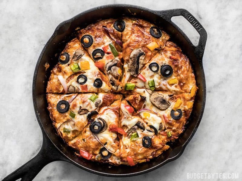 A simple overnight no knead dough makes a perfectly crispy yet thick crust on this no knead pan pizza. Deep dish pan pizza has never been easier. BudgetBytes.com