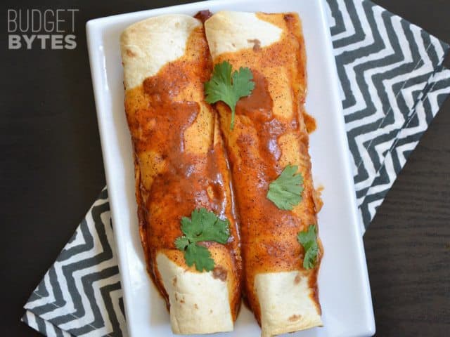 Two Creamy Chicken and Black Bean Enchiladas on a white plate 